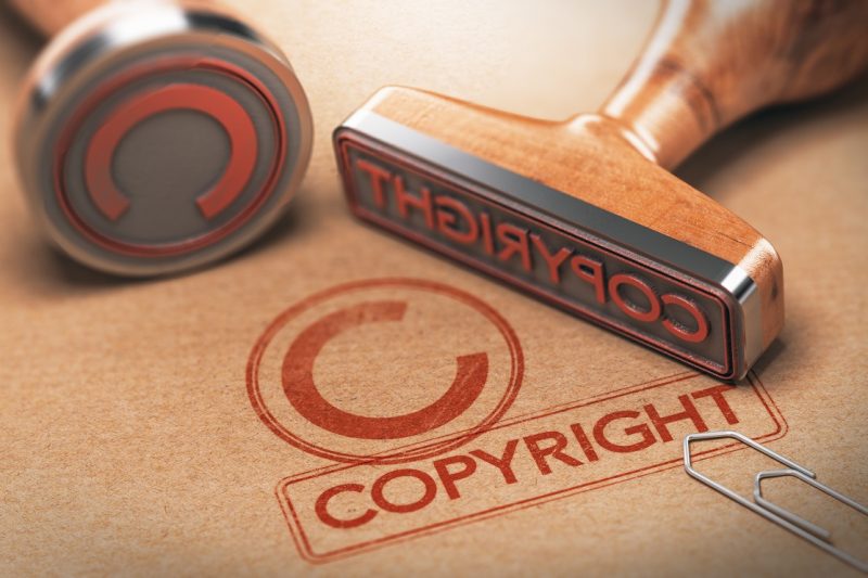 3D illustration of two rubber stamps with copyright word and symbol over kraft paper background, Concept of copyrighted material